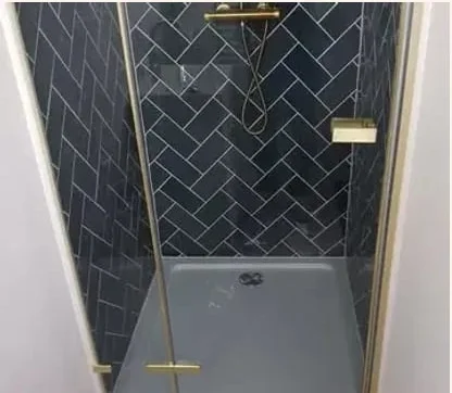 Douche met messing douchedeur, messing thermostaatkraan en donkerblauwe tegels in visgraatmotief